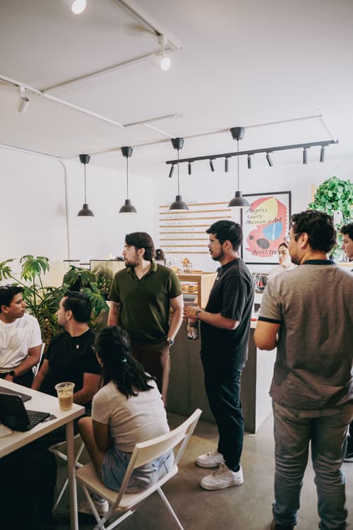 Asistentes conversando en el café del meetup